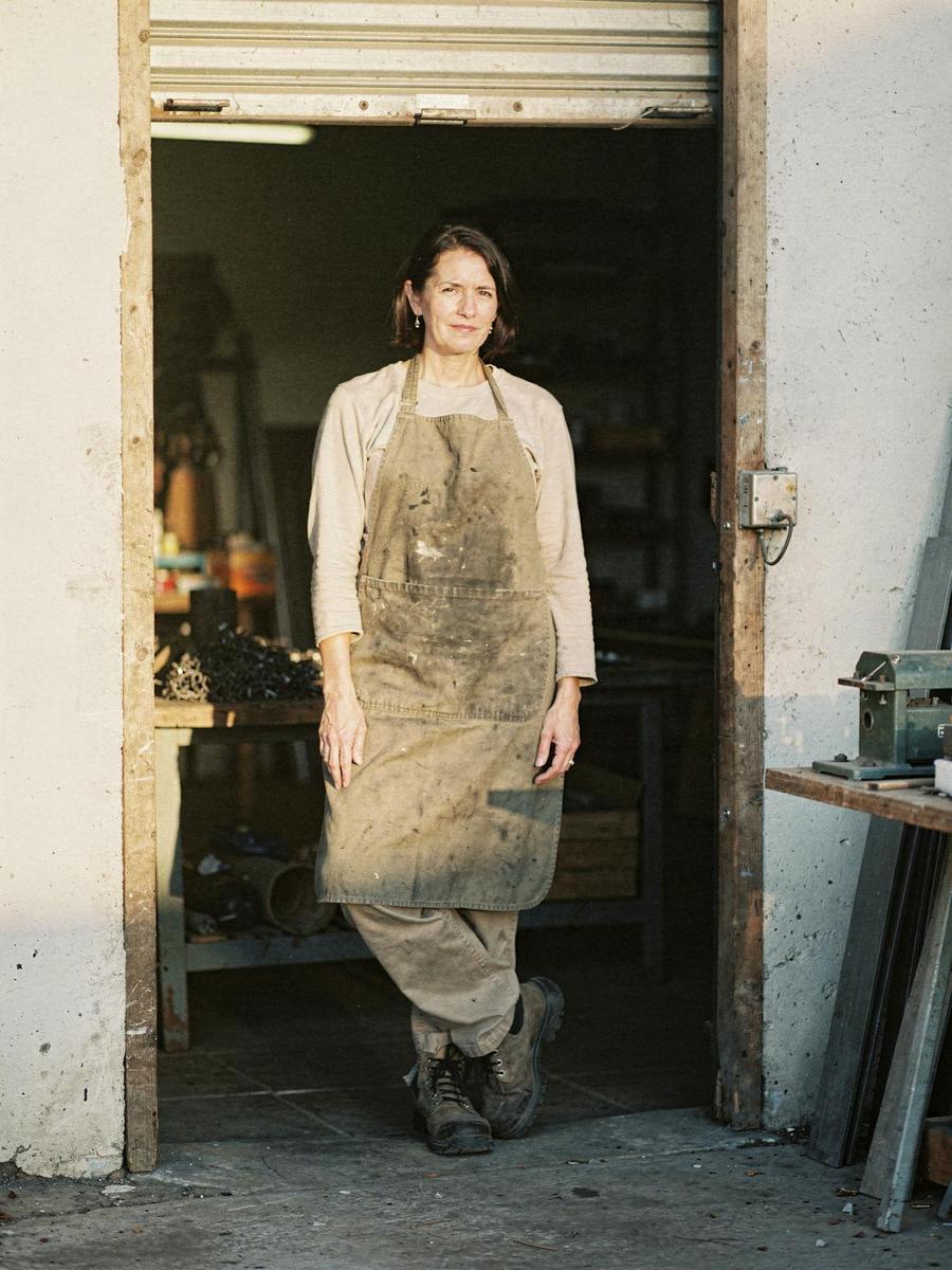 A self-employed tradeswoman standing in the doorway of her own workshop